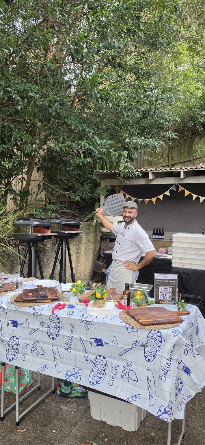 Stefano, head pizzaiolo at Azzurri, cooking authentic Neapolitan pizza live at a Sydney backyard event